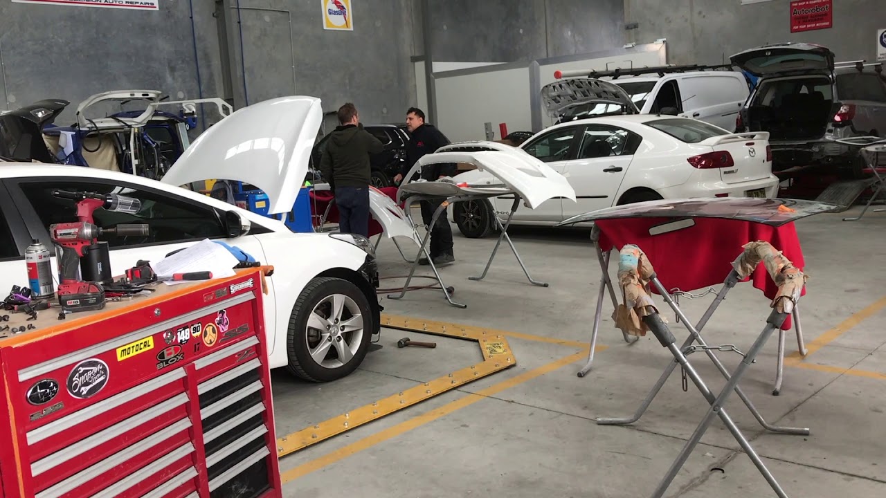 Vehicles under repair inside the Andrews Collision workshop in Ingleburn